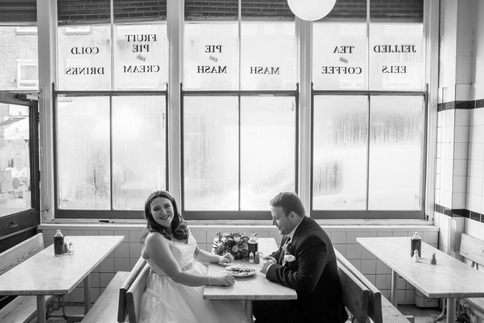 Wedding couple enjoying pie and mash in a traditional London cafe